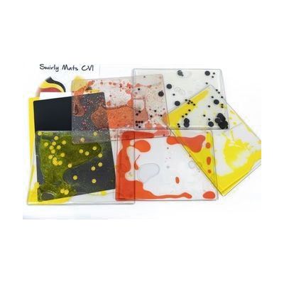 Swirly Mats CVI Kit including a red and clear mat, a yellow and clear mat, a red mat with confetti and glitter, a black mat, and a tabletop mat pack which includes a black polyethylene sheet, a yellow polyblend sheet, and white tabletop mat. The instruction book is shown poking out from underneath the tabletop mat pack.