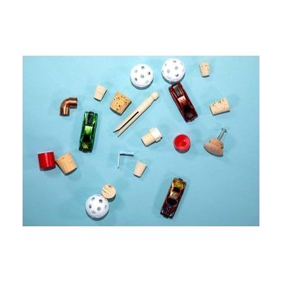 All the components of Pack A (wiffle balls, pins, corks, small toy cars) strewn out on a blue background.