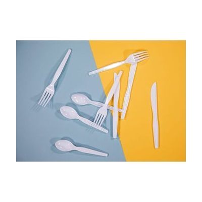 Three each of white plastic spoons, forks, and knives arranged on a yellow and light blue background.