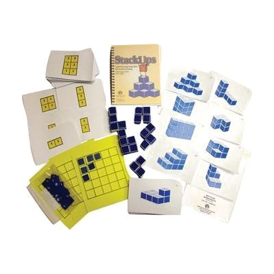 All components of the StackUps kit laid out on a white background. This includes the stacked cube arrangement cards, the raised line grid pack with blue square tiles, the mat plan card set, and a set of 20 blue cubes, as well as the printed manual.