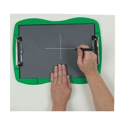 A sheet of tactile drawing film is attached to the curved green frame of the TactileDoodle. Two hands appear in the image; one is holding the film in place while the other draws a white cross in the center of the page with the black stylus