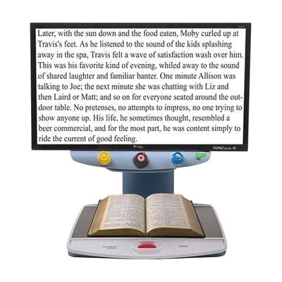 Desktop video magnifier with a mounted HD camera arm over a flat white reading platform and an integrated color display scree
