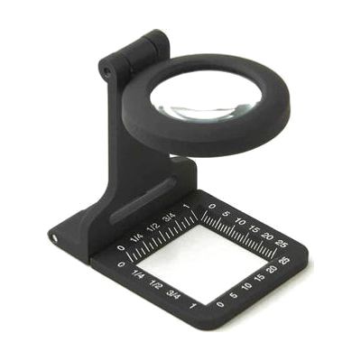 Small fold-flat loupe magnifier with metal frame, round 30mm glass lens, and ruler markings along the base