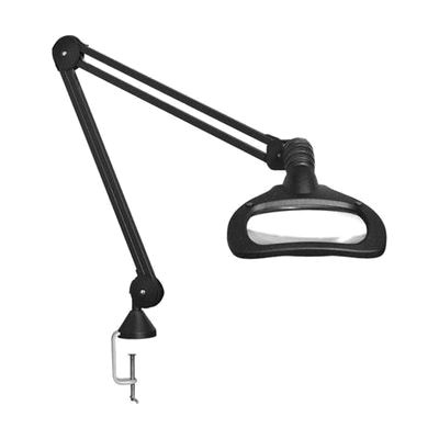 Black articulating desk lamp with large oval magnifying lens head mounted on a long adjustable arm, with edge clamp base