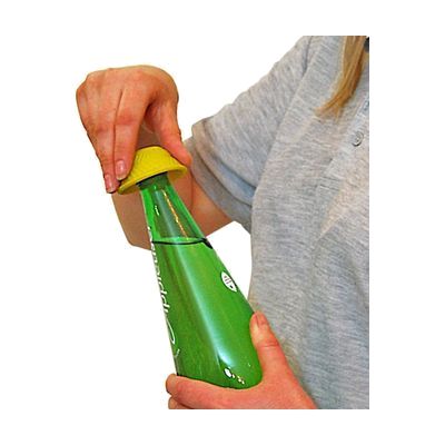 A yellow silicone disc-shaped bottle opener being used by a hand to twist the cap of a green bottle.